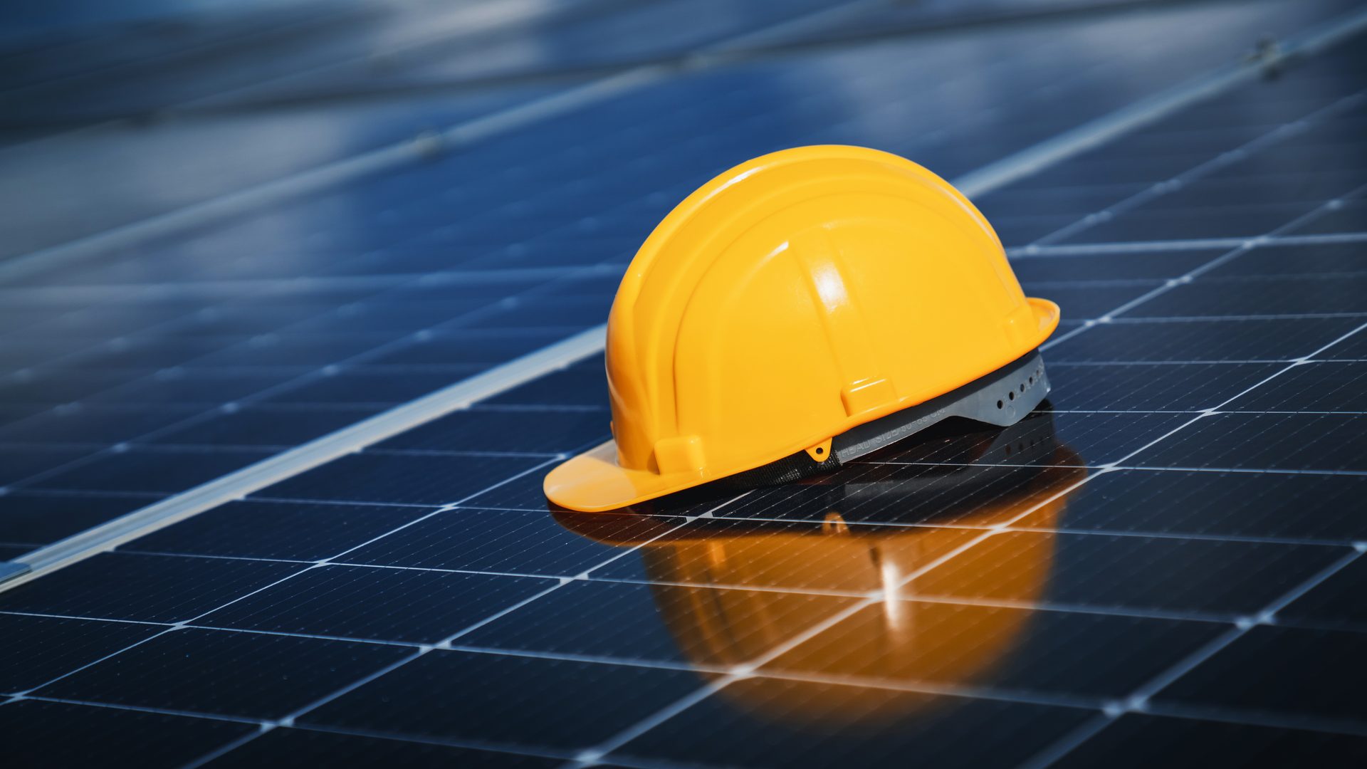 Yellow hard hat resting on a blue solar panel array