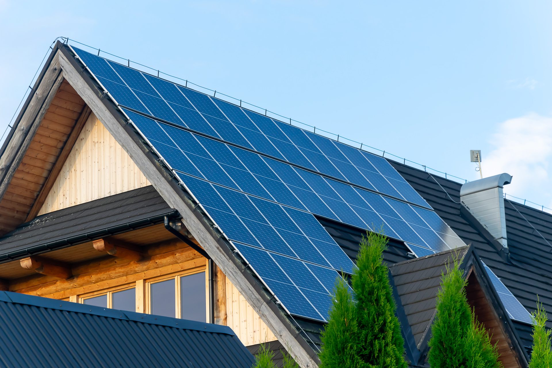 Steep A-frame roof with a large solar array on a sunny day
